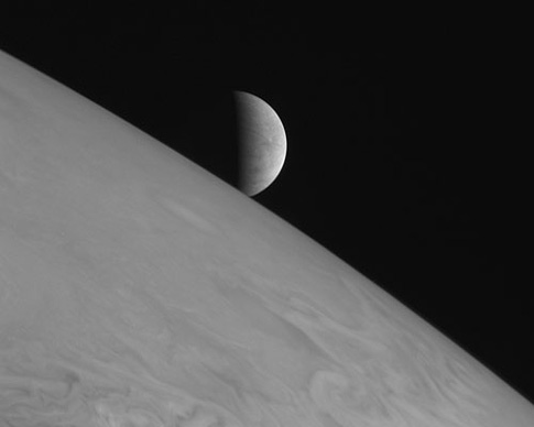 image of Europa rising over the limb of Jupiter